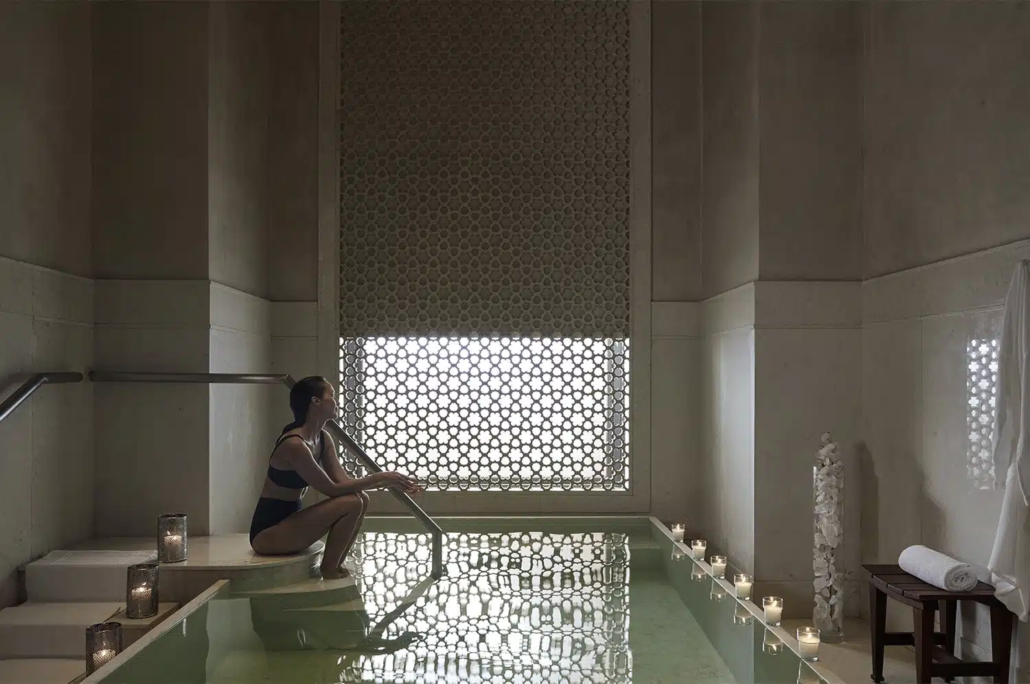 Royal Mansour hammam spa — white marble walls, mosaic arched niches, and Moorish latticework screens